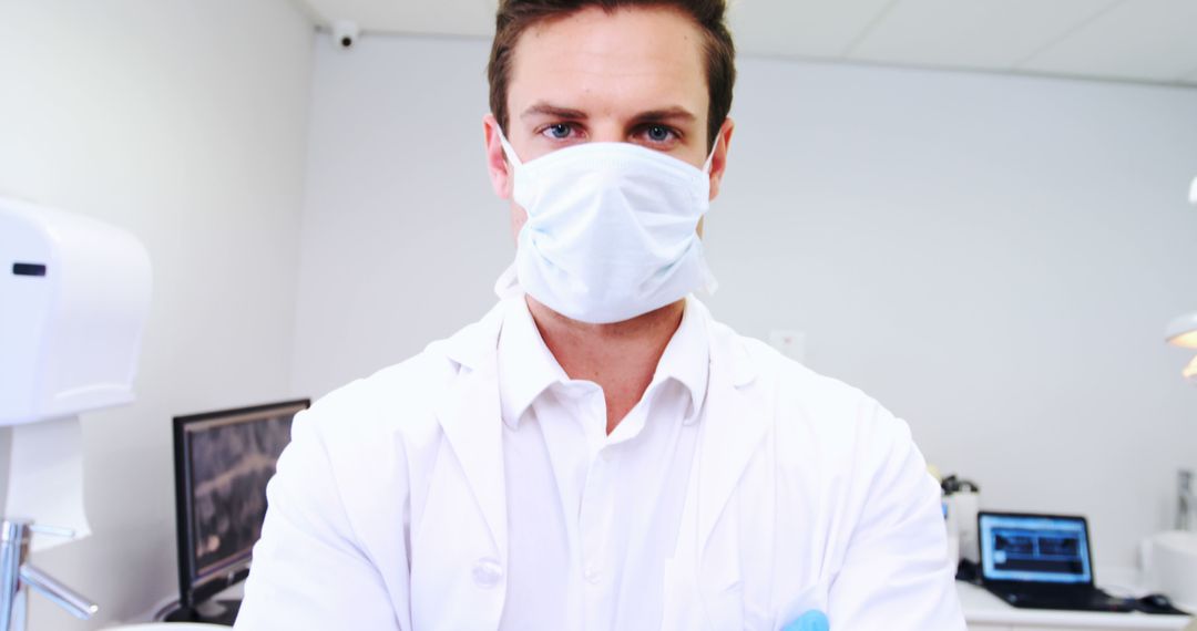 Confident Young Male Doctor Wearing Face Mask in a Modern Clinic - Free Images, Stock Photos and Pictures on Pikwizard.com