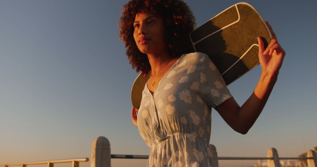 Confident Young Woman with Skateboard during Sunset - Free Images, Stock Photos and Pictures on Pikwizard.com