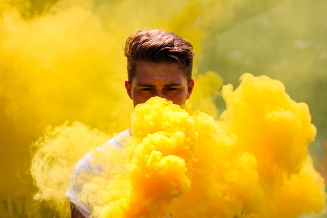 Man Surrounded by Yellow Smoke Cloud in Vibrant Outdoors Setting - Free Images, Stock Photos and Pictures on Pikwizard.com