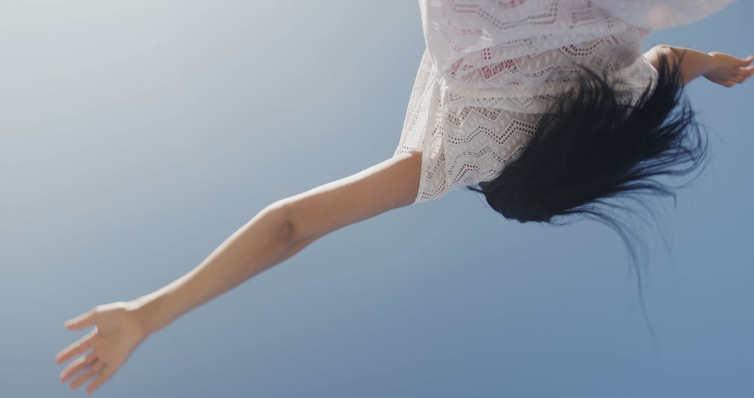 Woman experiencing freedom and joy under clear blue sky - Free Images, Stock Photos and Pictures on Pikwizard.com