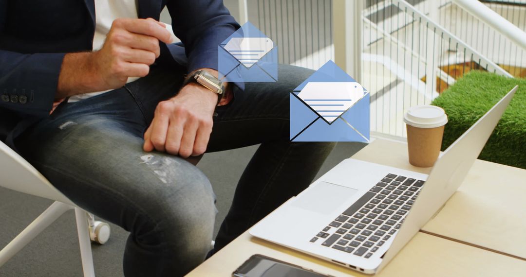 Businessman Receiving Emails on Smartwatch While Using Laptop