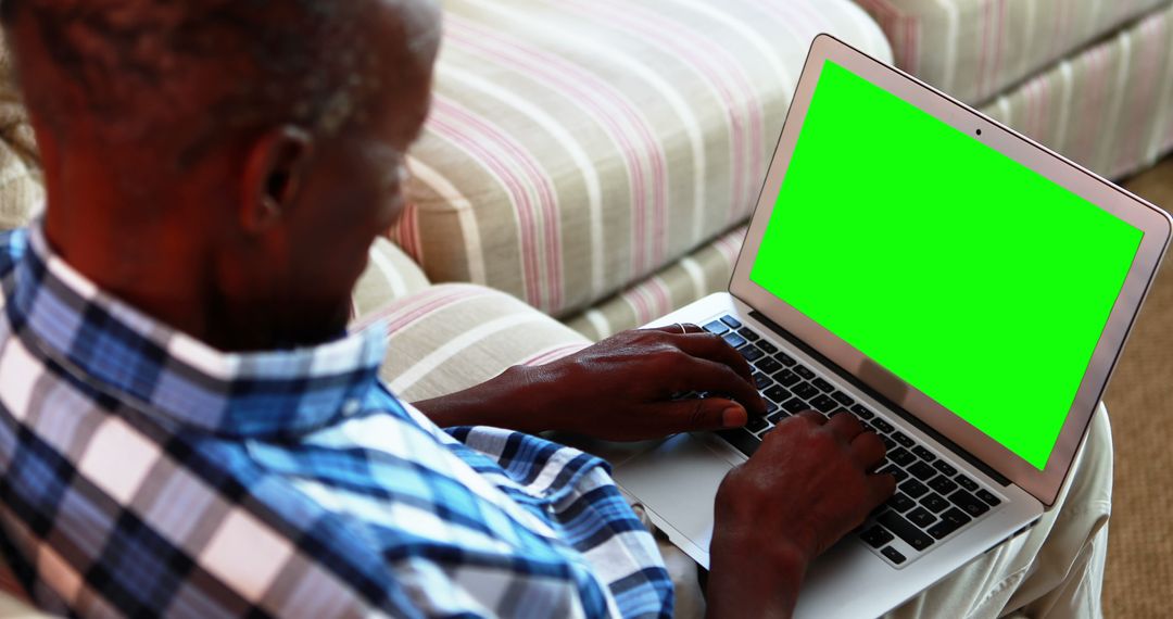 Man Typing on Laptop with Green Screen in Living Room - Free Images, Stock Photos and Pictures on Pikwizard.com