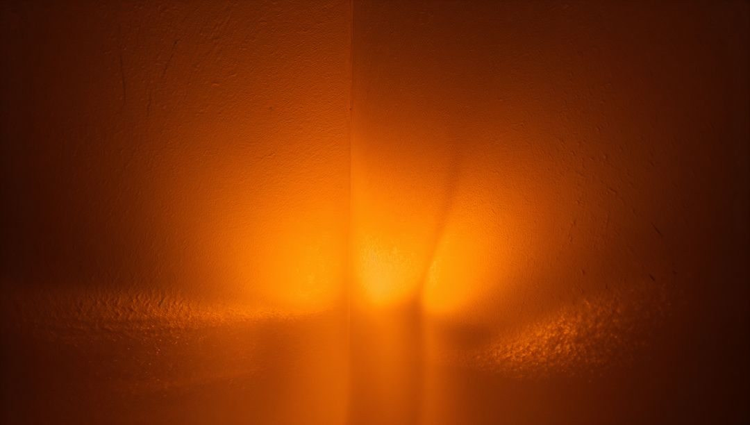 Warm Amber Glow Casting on Textured Plaster Corner with Subtle Stucco Grain