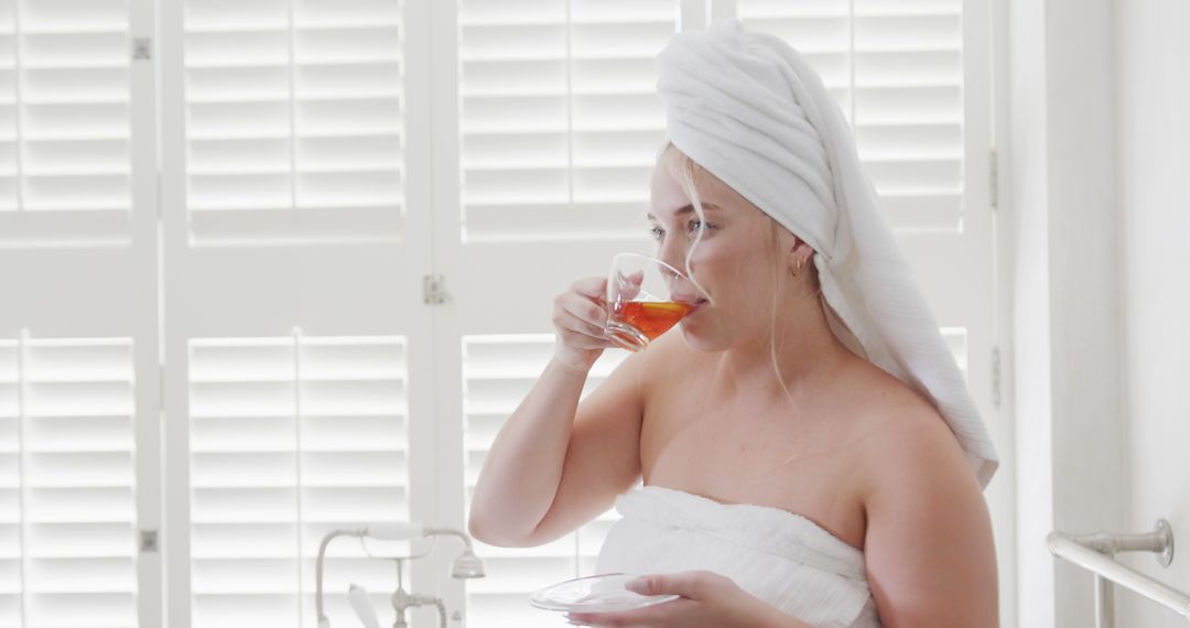 Woman Drinking Tea After Shower in Bright Bathroom - Free Images, Stock Photos and Pictures on Pikwizard.com