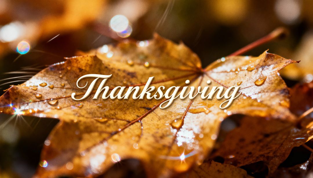 Golden maple leaf with dewdrops and Thanksgiving script, autumn bokeh closeup