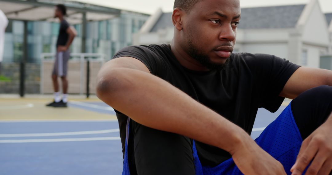 Focused Athlete Resting on Outdoor Basketball Court - Free Images, Stock Photos and Pictures on Pikwizard.com