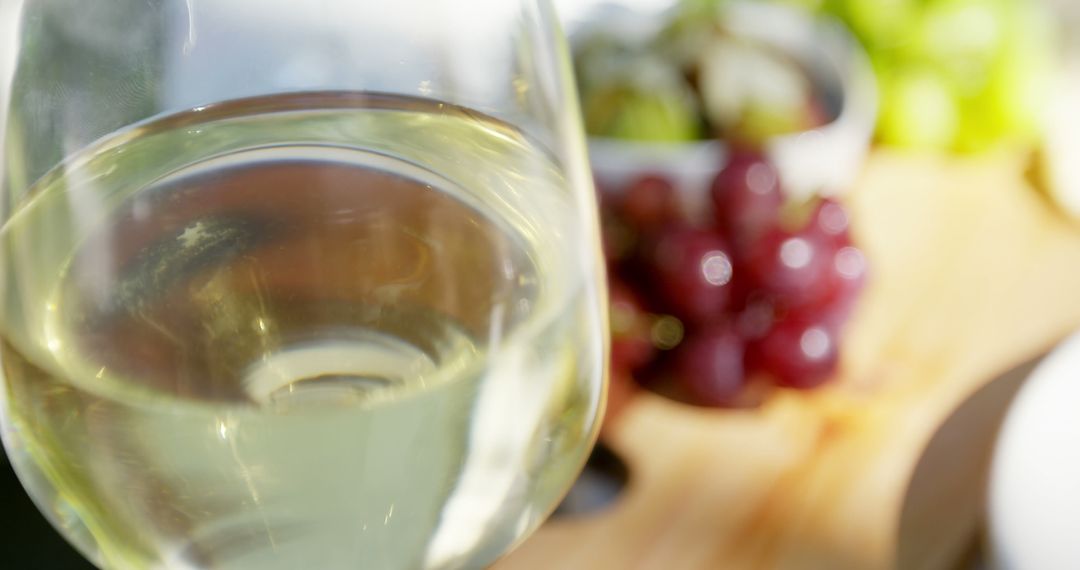 Close-Up of Glass of White Wine with Grapes in Background - Free Images, Stock Photos and Pictures on Pikwizard.com