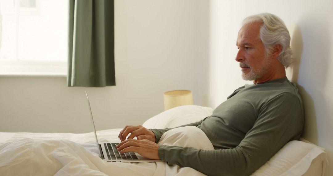 Senior Man Using Laptop in Bedroom - Free Images, Stock Photos and Pictures on Pikwizard.com