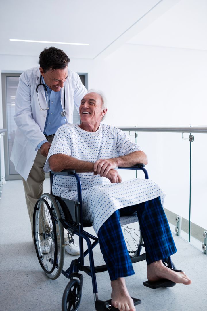 Doctor interacting with male senior patient on a wheelchair - Free Images, Stock Photos and Pictures on Pikwizard.com
