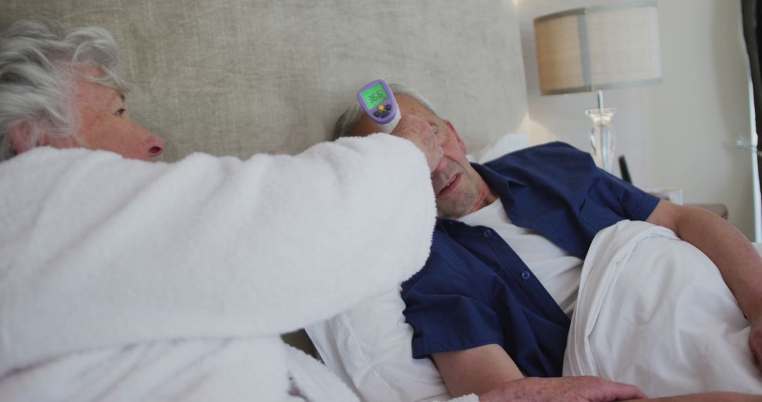 Elderly Woman Checking Temperature of Ill Husband in Bed - Free Images, Stock Photos and Pictures on Pikwizard.com