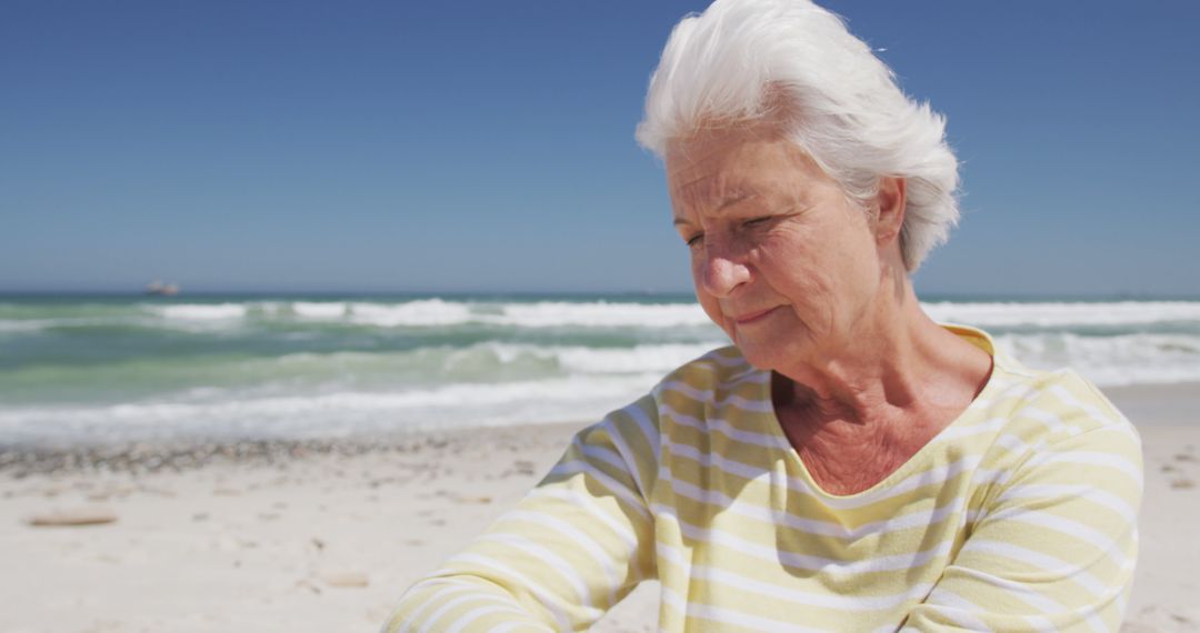 Senior Woman Relaxing on Beach - Free Images, Stock Photos and Pictures on Pikwizard.com