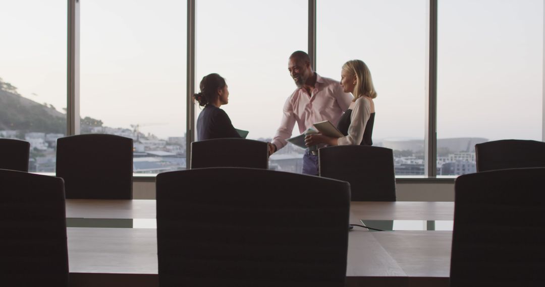 Three Business Professionals Shaking Hands in Modern Conference Room - Free Images, Stock Photos and Pictures on Pikwizard.com