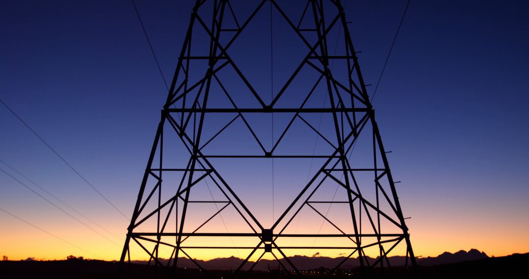 Silhouetted against a twilight sky, a power transmission tower stands tall, with copy space - Free Images, Stock Photos and Pictures on Pikwizard.com