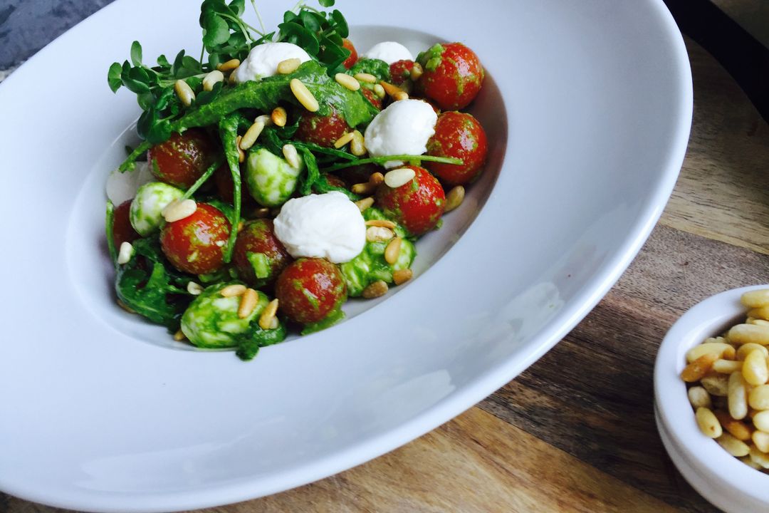 Cherry Tomato and Creamy Mozzarella Salad Tossing in Basil Pesto with Arugula and Pine Nuts