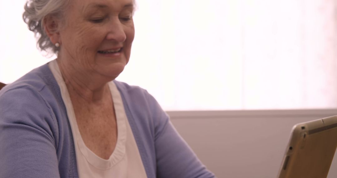 Elderly Woman Using Digital Tablet and Smiling - Free Images, Stock Photos and Pictures on Pikwizard.com