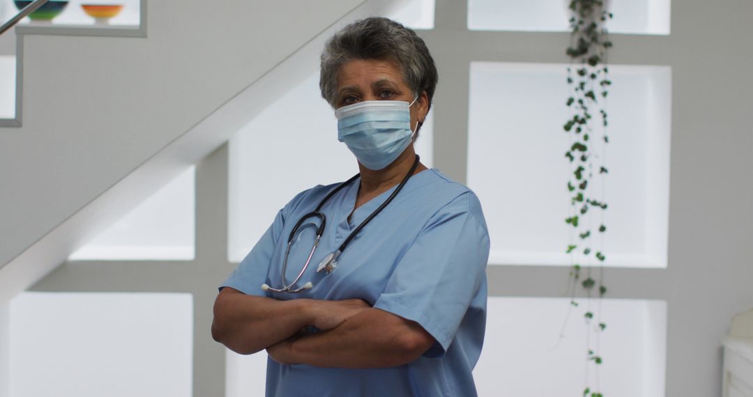 Senior Nurse Wearing Mask with Arms Crossed in Hospital - Free Images, Stock Photos and Pictures on Pikwizard.com