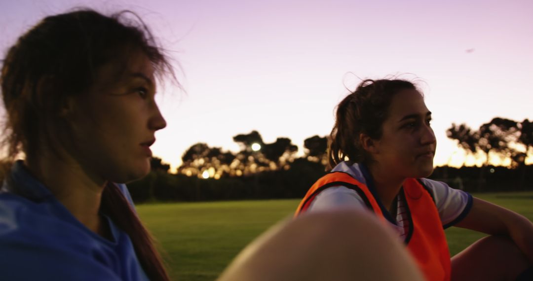 Female athletes relaxing on sports field at sunset - Free Images, Stock Photos and Pictures on Pikwizard.com