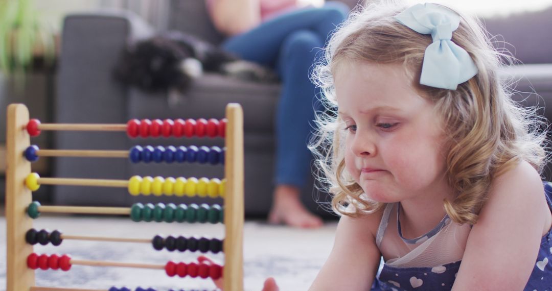 Young Girl Concentrating on Abacus While Sitting on Floor at Home - Free Images, Stock Photos and Pictures on Pikwizard.com