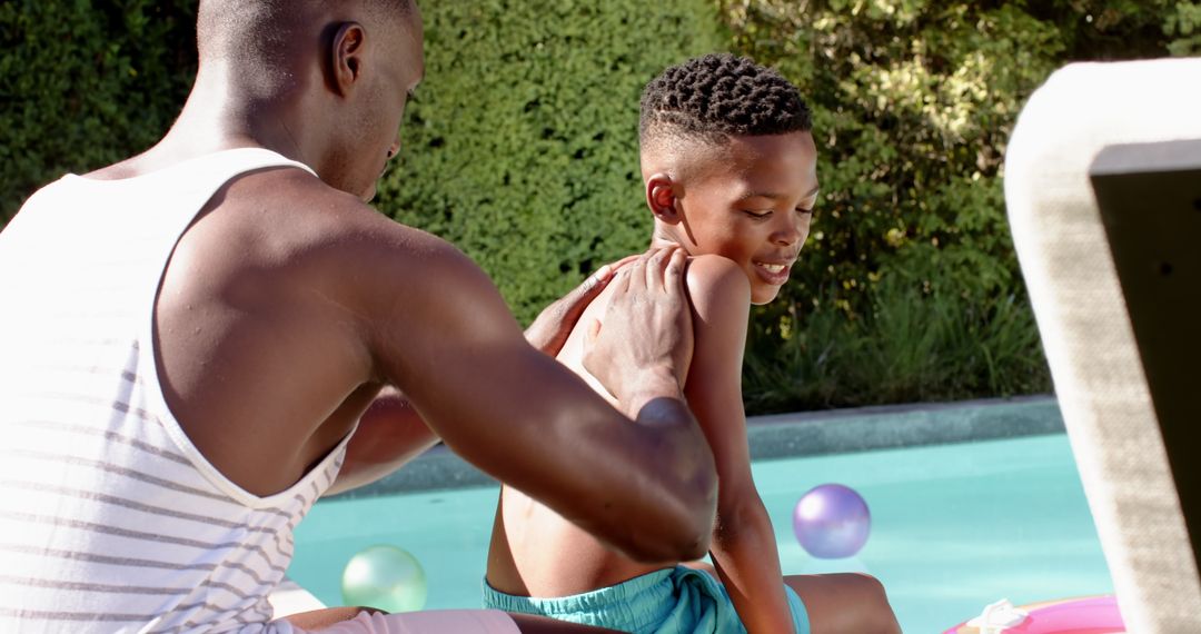 Father Applying Sunscreen to Son by Poolside for Summer Fun
