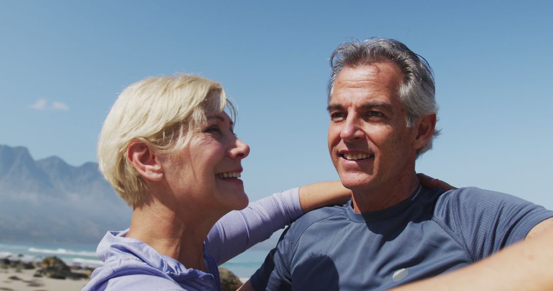 Happy Mature Couple Embracing on Beach on Sunny Day - Free Images, Stock Photos and Pictures on Pikwizard.com