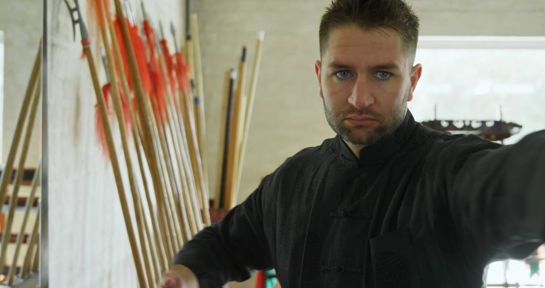 Martial Artist Practicing in Dojo with Traditional Weaponry in Background - Free Images, Stock Photos and Pictures on Pikwizard.com