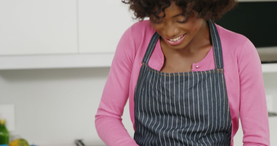 Smiling Woman Wearing Apron Cooking in Modern Kitchen - Free Images, Stock Photos and Pictures on Pikwizard.com