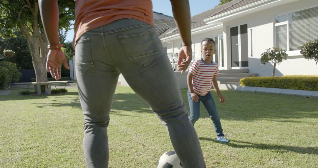 African American Father and Son Playing Football in Garden on Sunny Day - Free Images, Stock Photos and Pictures on Pikwizard.com