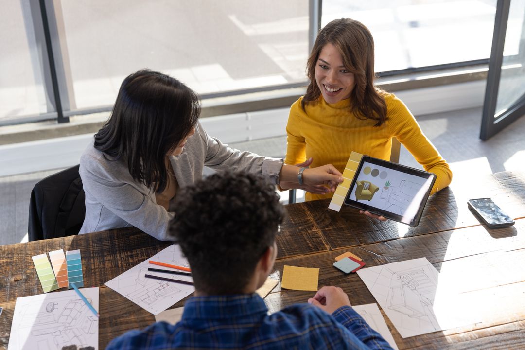 Creative Team Discussing Design Ideas Using Tablet and Swatches