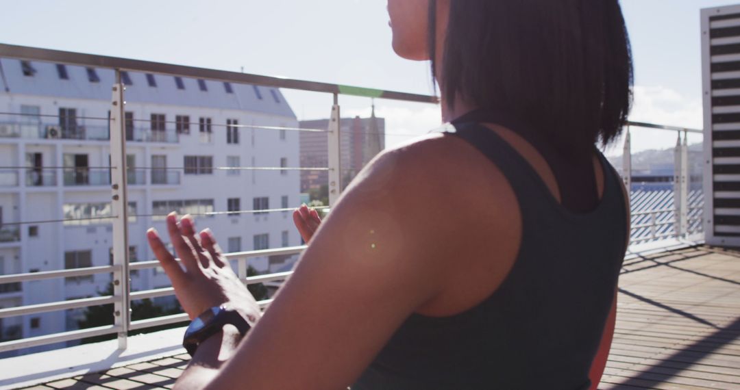 Woman Meditating on Apartment Balcony in Morning Sunlight - Free Images, Stock Photos and Pictures on Pikwizard.com