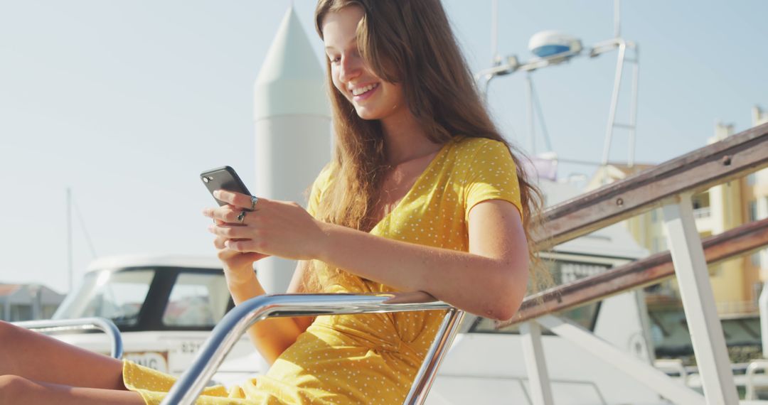 Young Woman Enjoying Sunny Day on Boat Using Smartphone - Free Images, Stock Photos and Pictures on Pikwizard.com