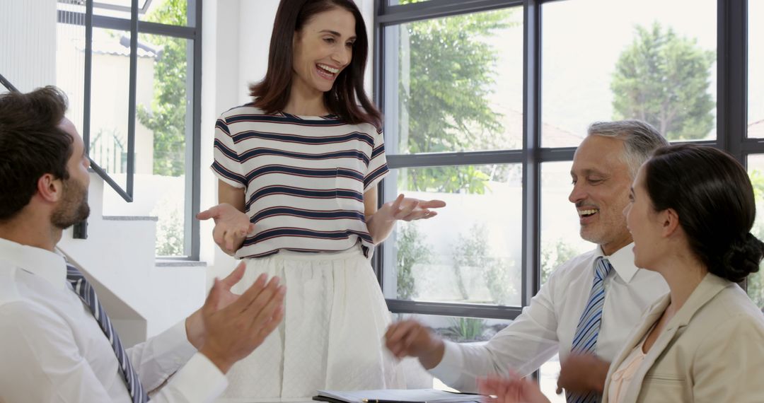 Smiling Business Team Applauding Female Colleague in Modern Office - Free Images, Stock Photos and Pictures on Pikwizard.com