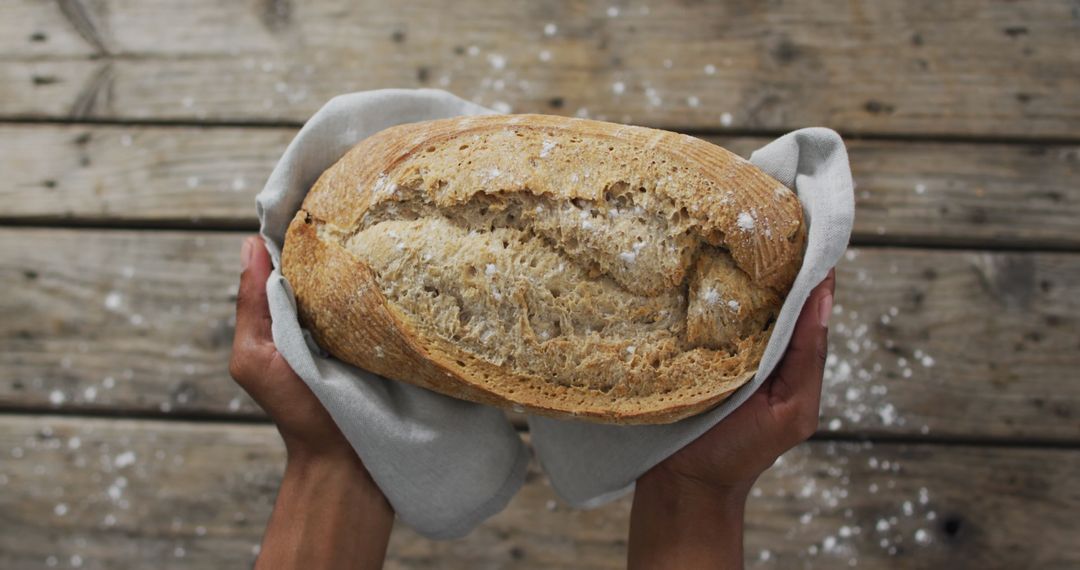 Homemade Rustic Bread with Textured Crust on Wooden Surface