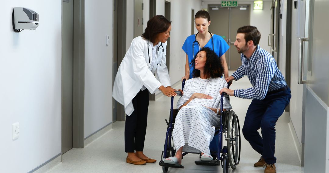 Medical Staff Assisting Woman in Wheelchair in Hospital Corridor - Free Images, Stock Photos and Pictures on Pikwizard.com