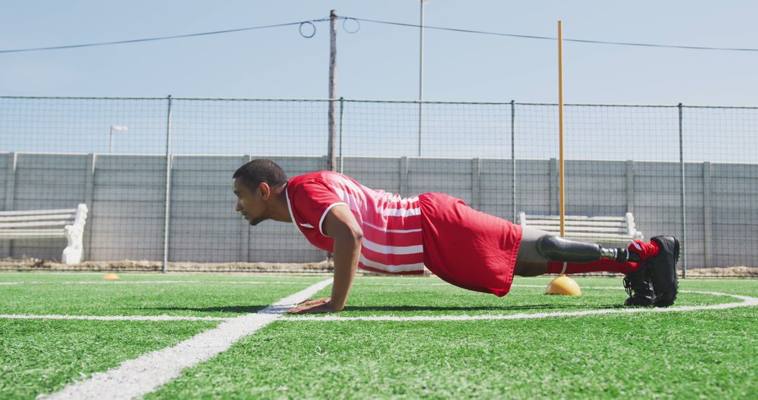 Disabled biracial male football player, doing push-ups on outdoor pitch - Free Images, Stock Photos and Pictures on Pikwizard.com