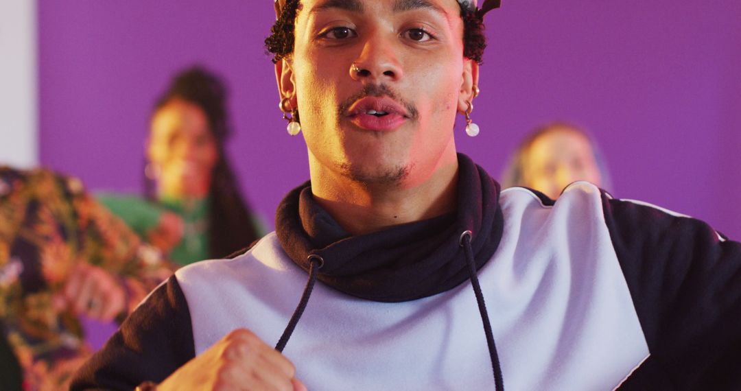 Confident Young Man Dancing in Studio with Purple Background - Free Images, Stock Photos and Pictures on Pikwizard.com