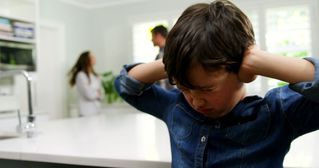 Young Boy Distraught While Parents Argue in Background - Free Images, Stock Photos and Pictures on Pikwizard.com