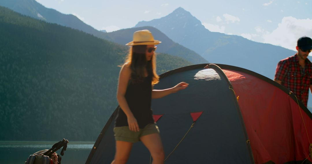 Couple Setting Up Tent by Scenic Lake with Mountain View