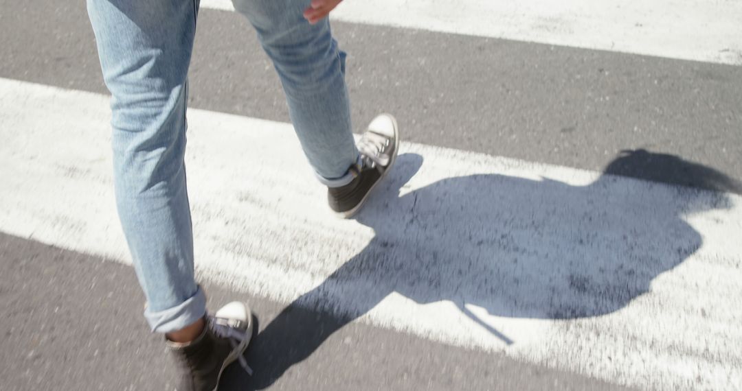 Legs of biracial man in jeans and baseball boots on pedestrian crossing in sunny street, copy space - Free Images, Stock Photos and Pictures on Pikwizard.com