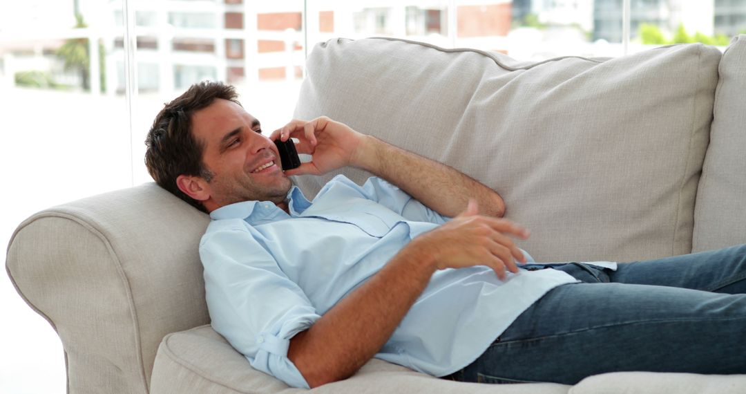 Relaxed Man Lying on Couch Talking on Phone in Casual Home Setting - Free Images, Stock Photos and Pictures on Pikwizard.com