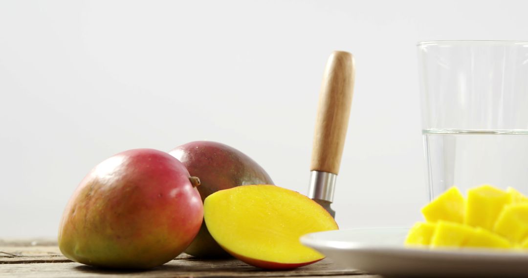 Fresh Mangoes Sliced and Whole on Rustic Wooden Table - Free Images, Stock Photos and Pictures on Pikwizard.com