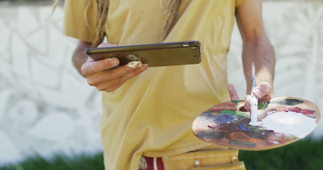 Artist Holding Palette and Tablet During Outdoor Painting - Free Images, Stock Photos and Pictures on Pikwizard.com