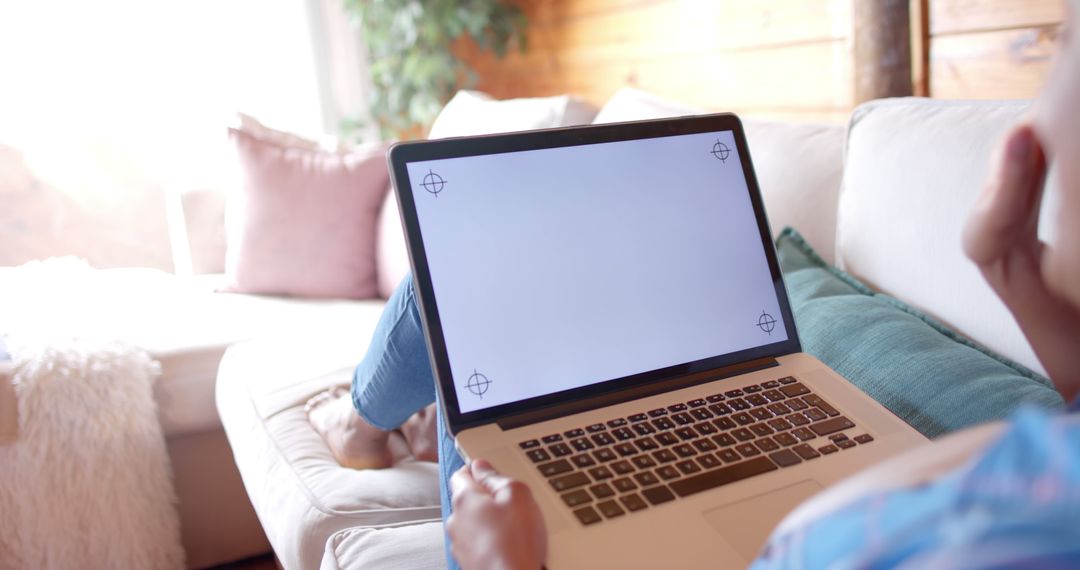 Person Relaxing on Couch Holding Laptop with Blank Screen - Free Images, Stock Photos and Pictures on Pikwizard.com