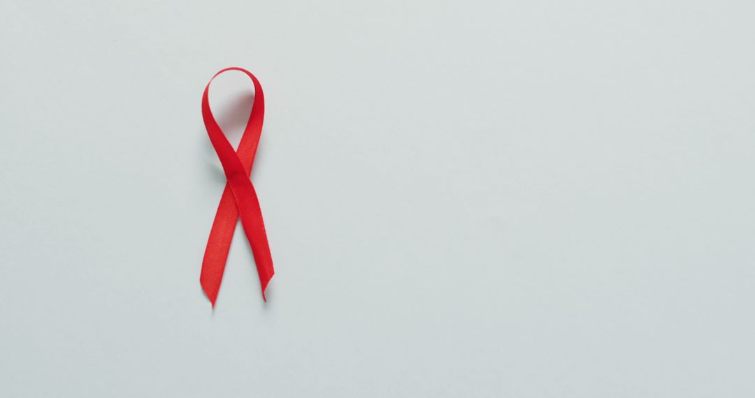 Red Ribbon on White Background Symbolizing AIDS Awareness - Free Images, Stock Photos and Pictures on Pikwizard.com