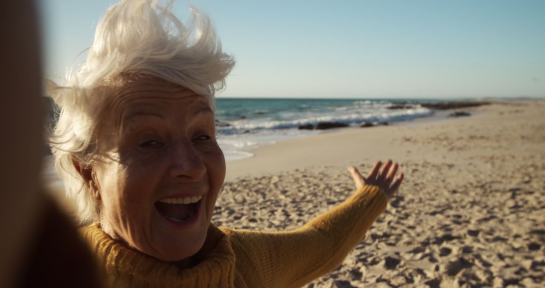 Senior Woman Enjoying a Windy Day at the Beach - Free Images, Stock Photos and Pictures on Pikwizard.com