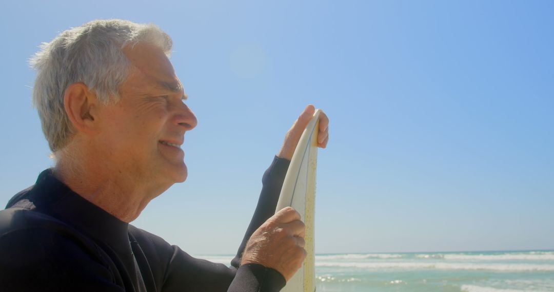 Senior Surfer Smiling with Surfboard on Sunny Beach