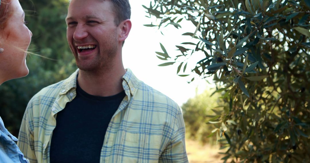 Man Laughing Outdoors Near Olive Tree in Sunshine - Free Images, Stock Photos and Pictures on Pikwizard.com