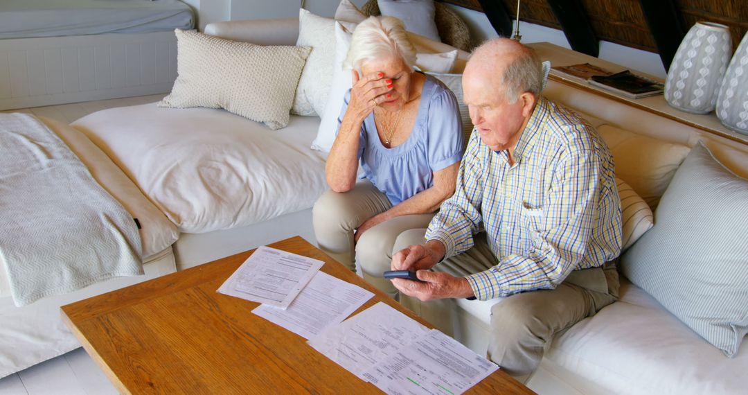 Elderly couple anxiously reviews bills at home. - Free Images, Stock Photos and Pictures on Pikwizard.com