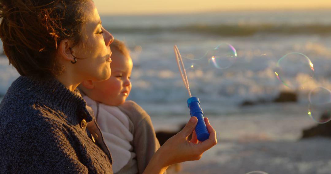 Mother and Baby Blowing Bubbles at Sunset Beach - Free Images, Stock Photos and Pictures on Pikwizard.com