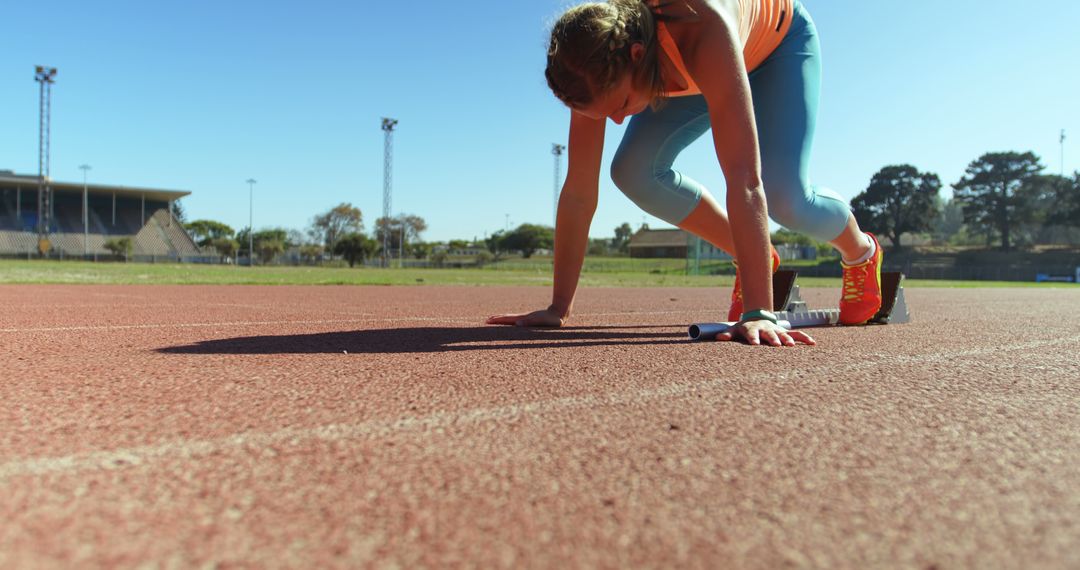 Female Track Athlete Preparing for Race on Sunny Day - Free Images, Stock Photos and Pictures on Pikwizard.com