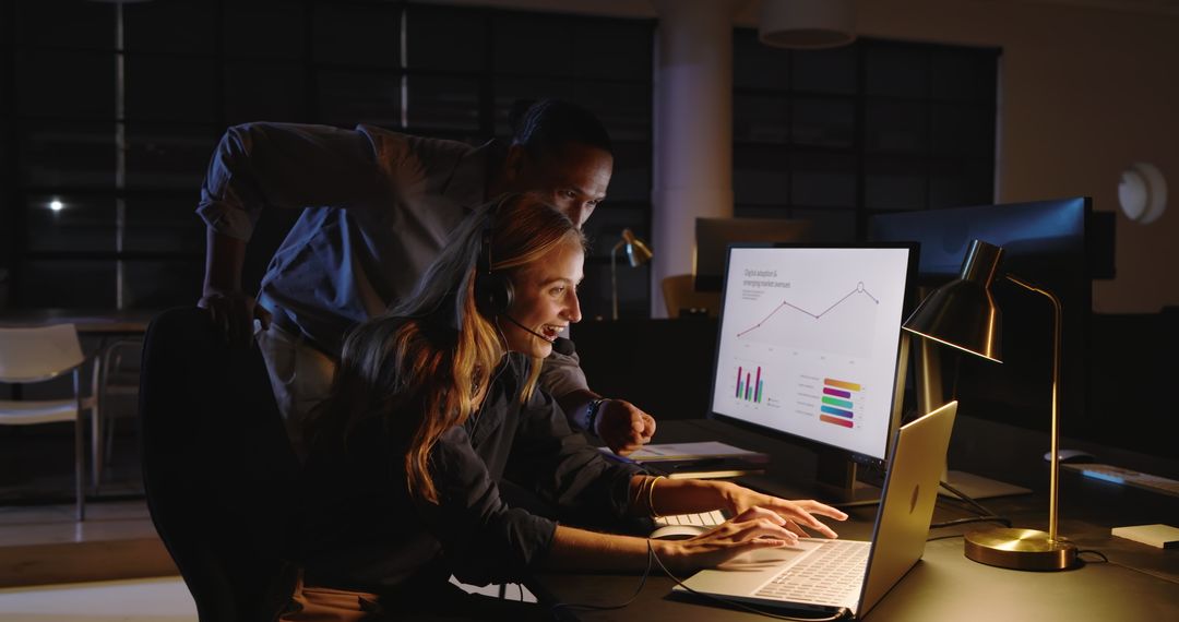 Diverse Team Analyzing Business Data Late at Night in Office